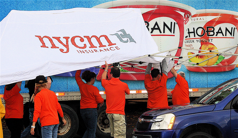 Employees putting up an NYCM canopy