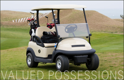 Golf cart parked on golf course carrying bags and clubs