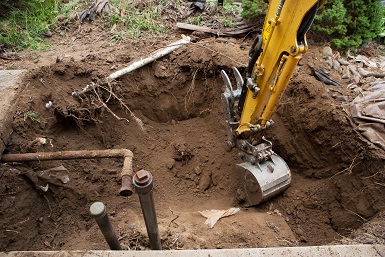 backhoe digging around pipes